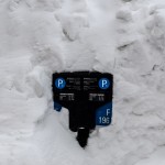 Parking sign buried in snow